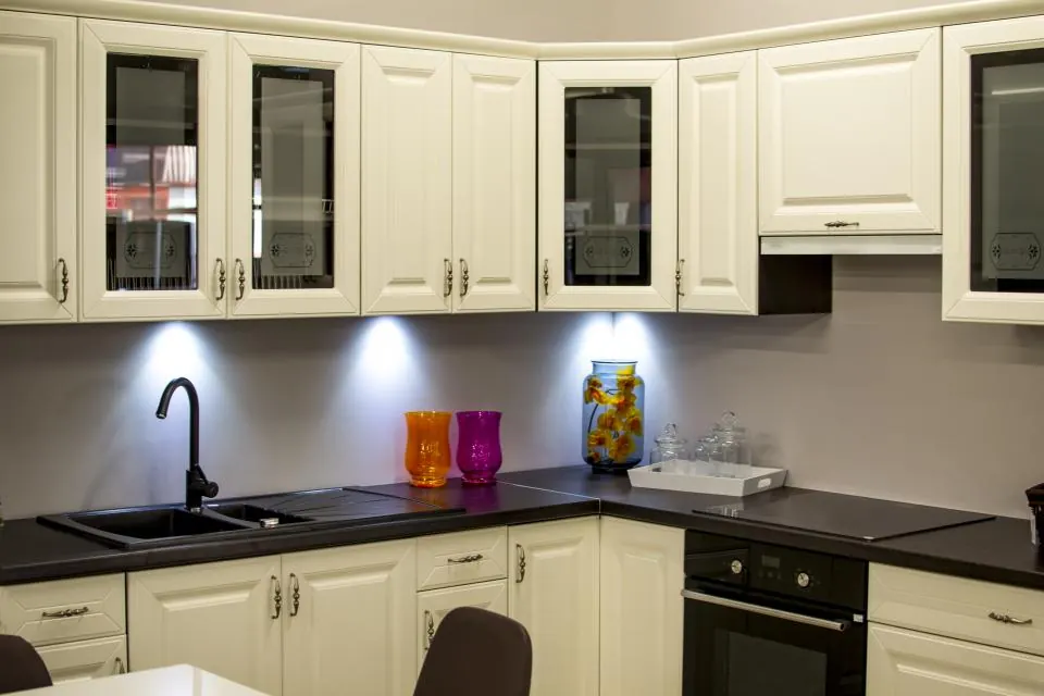 A finished kitchen with cream cabinets and under-cabinet lights
