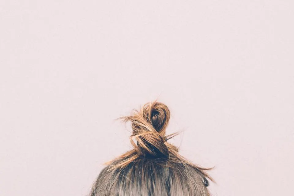 Hair twisted into a loose top bun