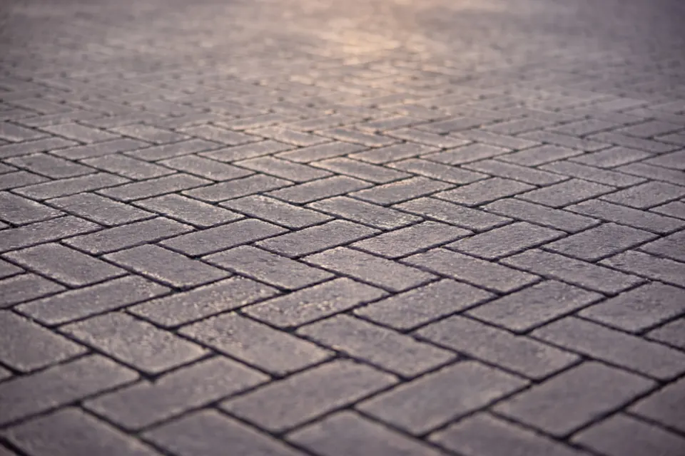A close-up of grey paving stones laid in a herringbone pattern